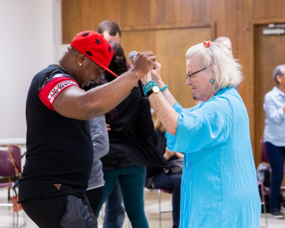 young man and older woman dance