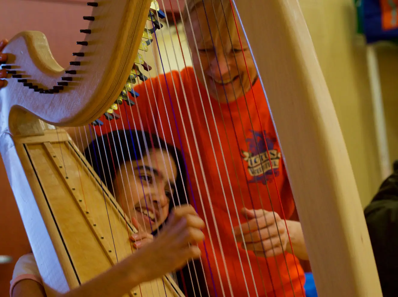 harpest showing a child how to play the harp